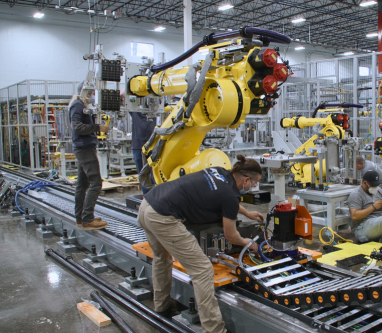 ATS Industrial Automation Employee working on EV battery assembly equipment.
