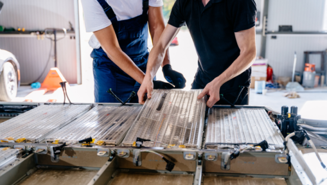 Two people working on an EV battery pack