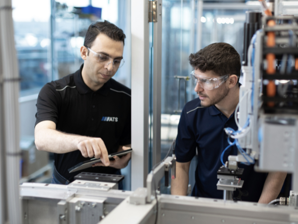 Two ATS employees working on equipment