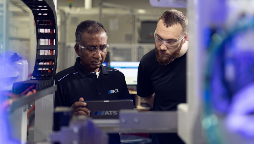 Two ATS employees working on automation equipment