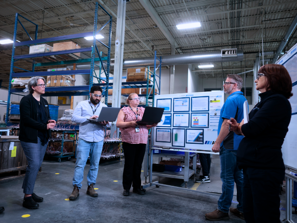 Automation team on shop floor discussing a project